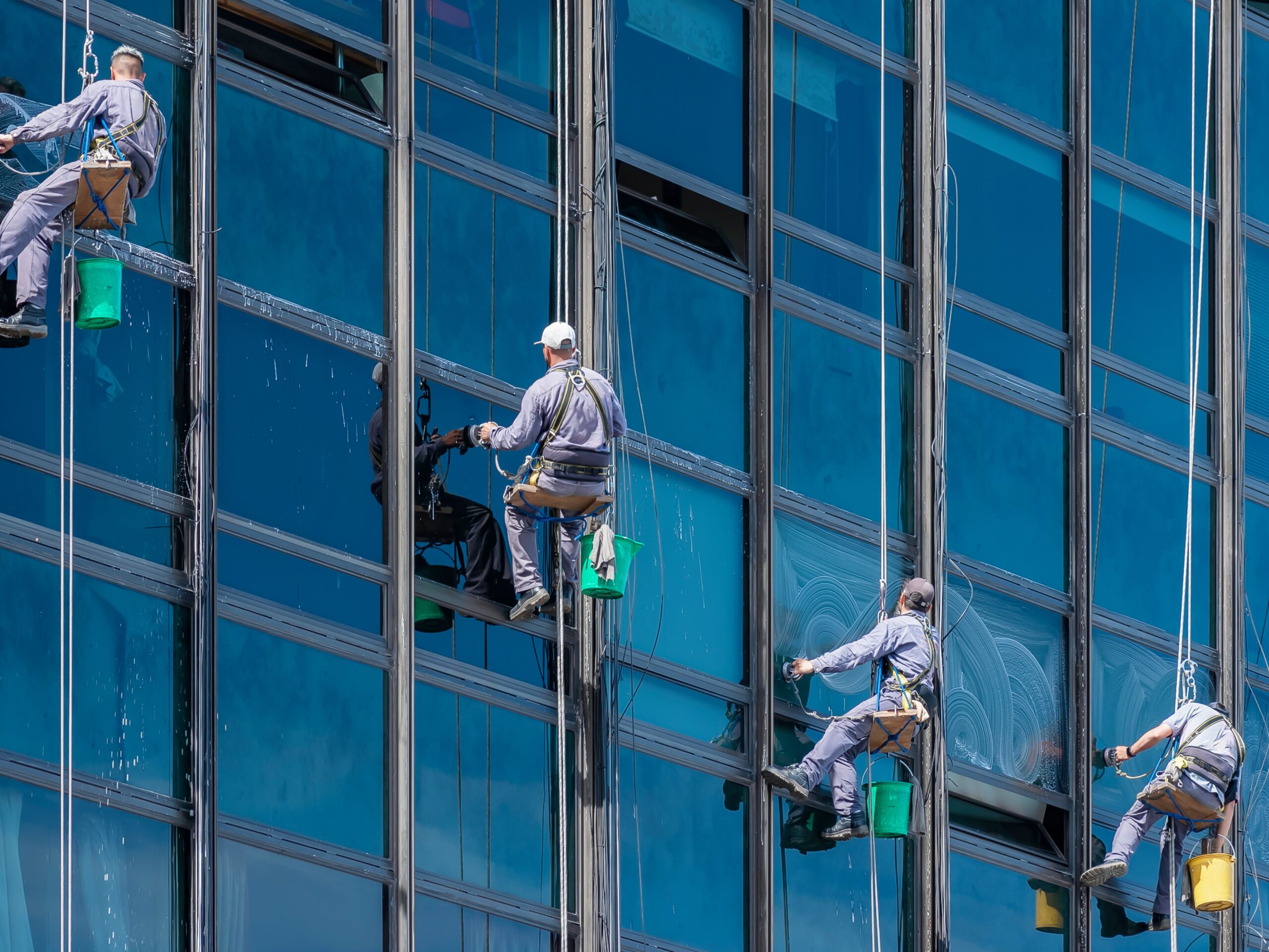 four-men-glass-cleaning-service-high-rise-building-city