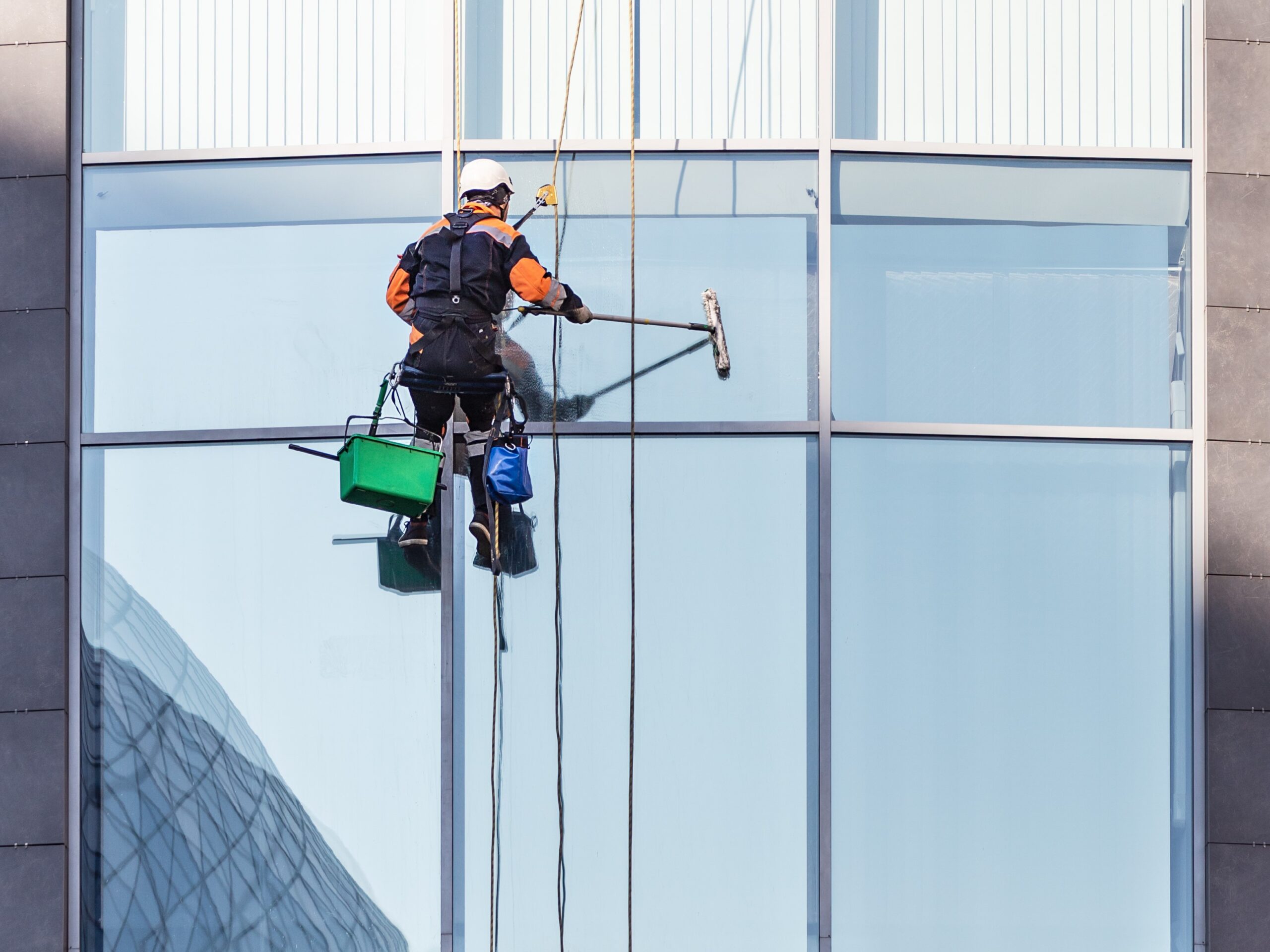 Worker cleaning windows of and office high-rise building