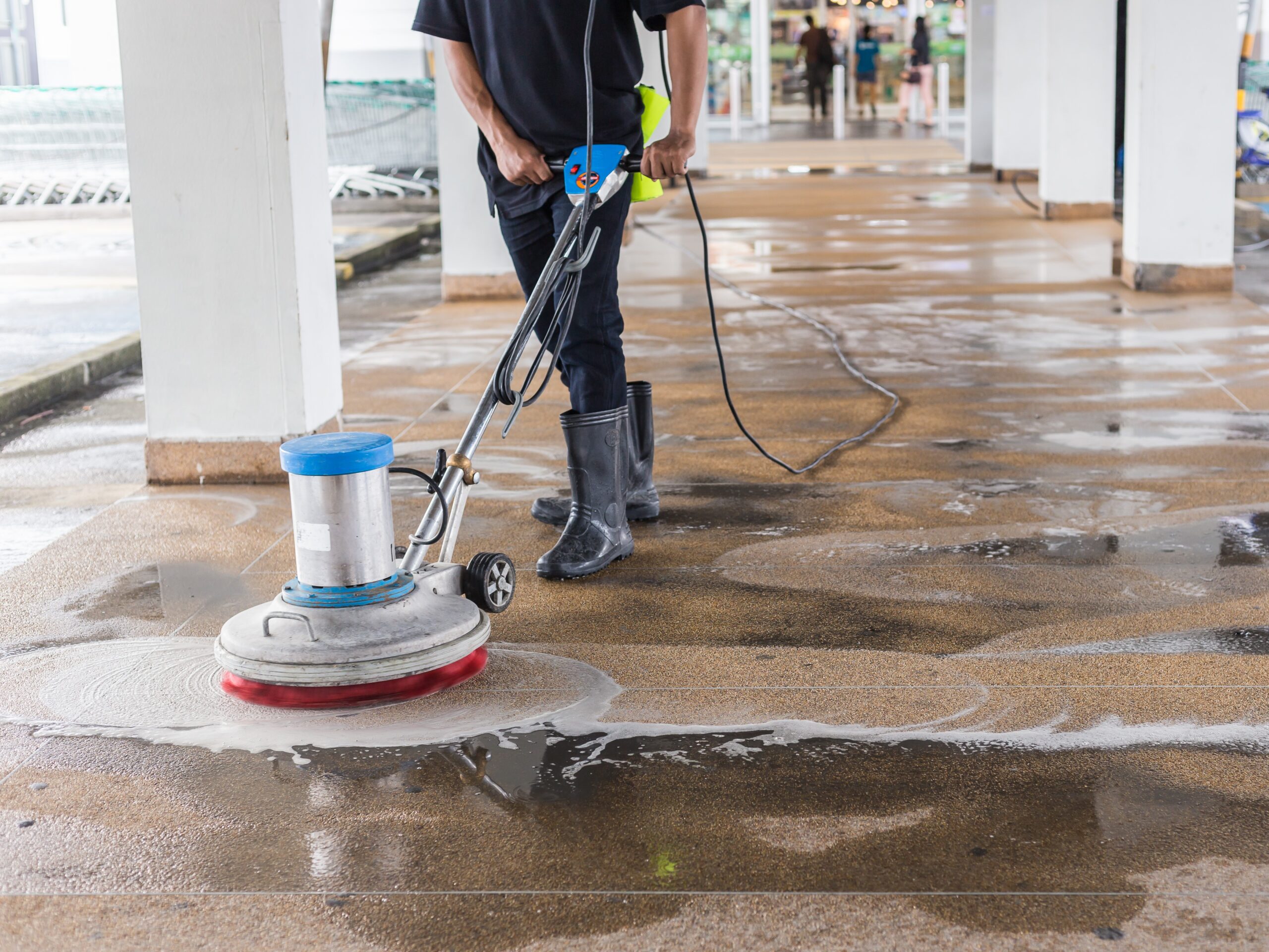 Asian worker cleaning sand wash exterior walkway
