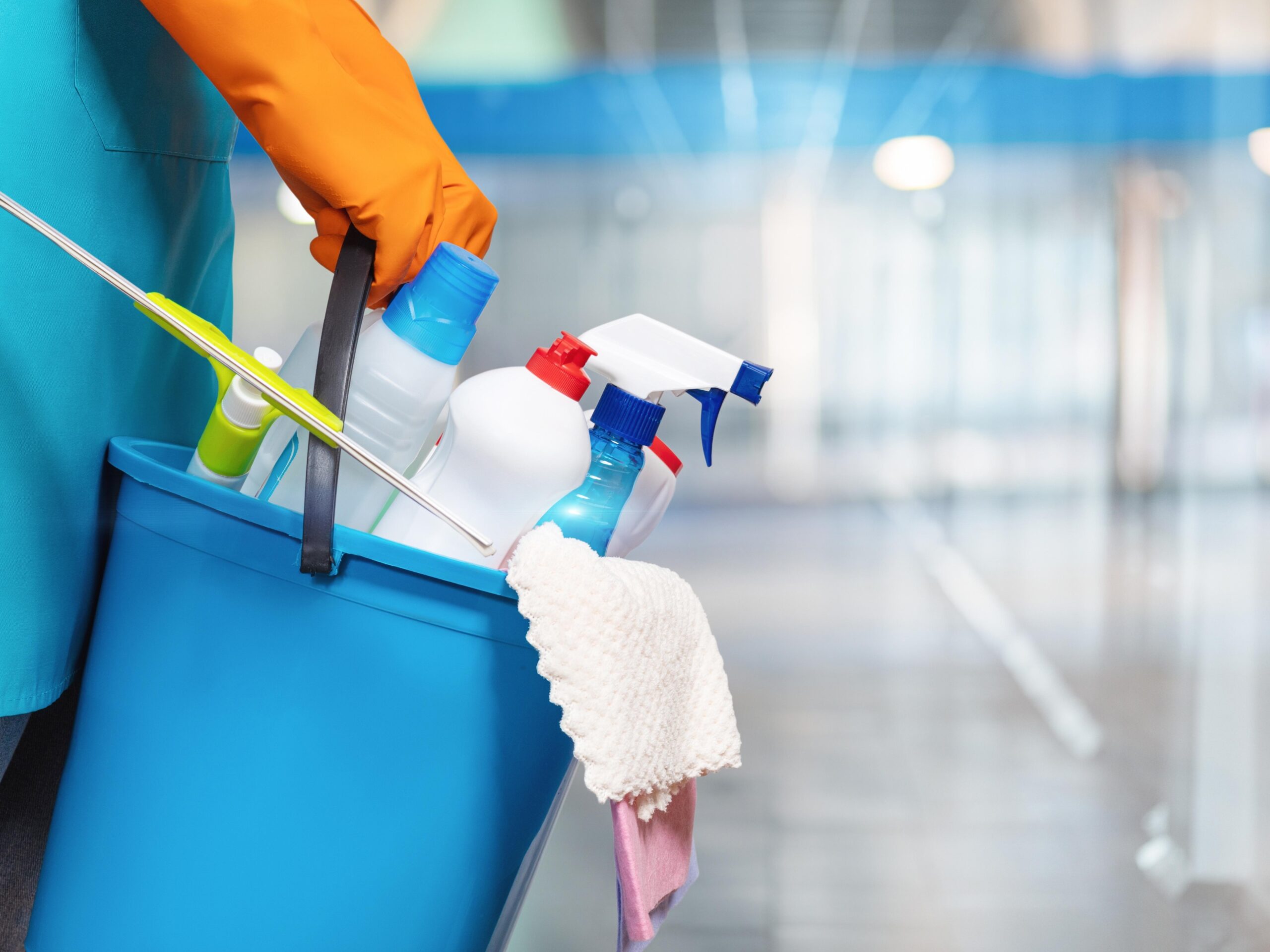 The concept of cleaning services. A cleaning lady is holding a bucket of cleaning products.