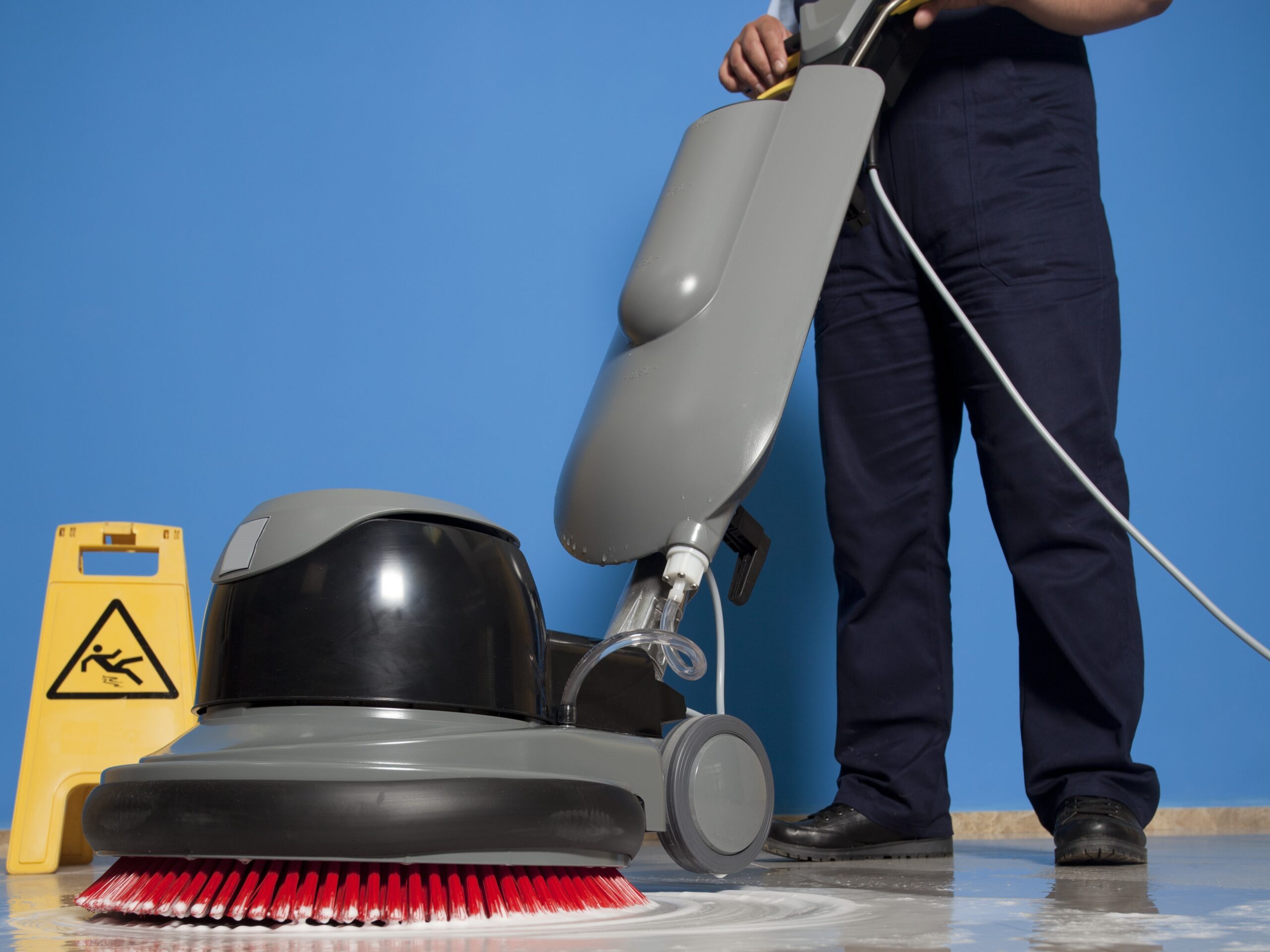 A Man worker cleaning the floor with scrubber machine. image
