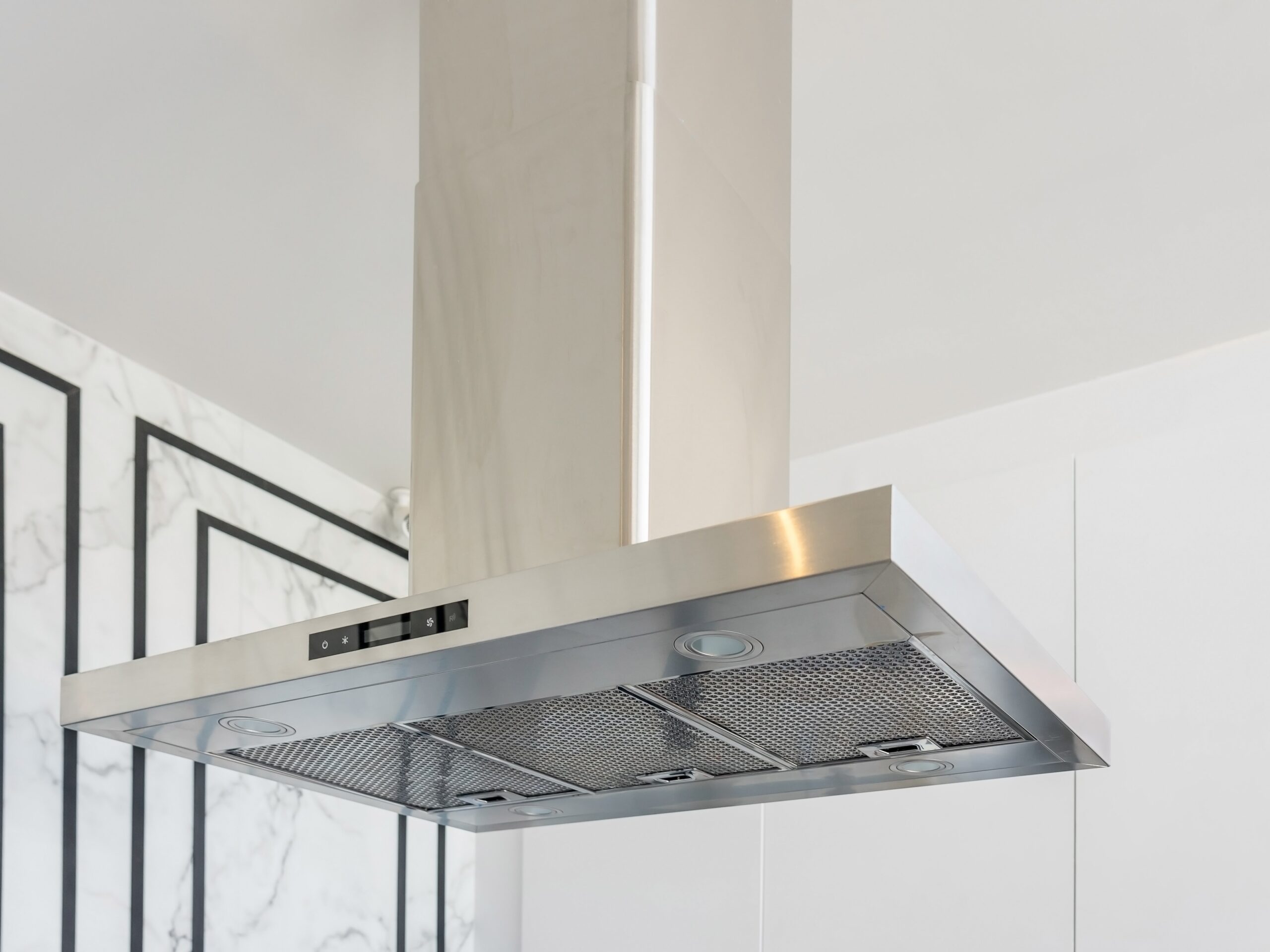 Modern stainless steel And Range hood in the kitchen interior. Stainless Steel Cooker Hood with light on. Kitchen Appliances