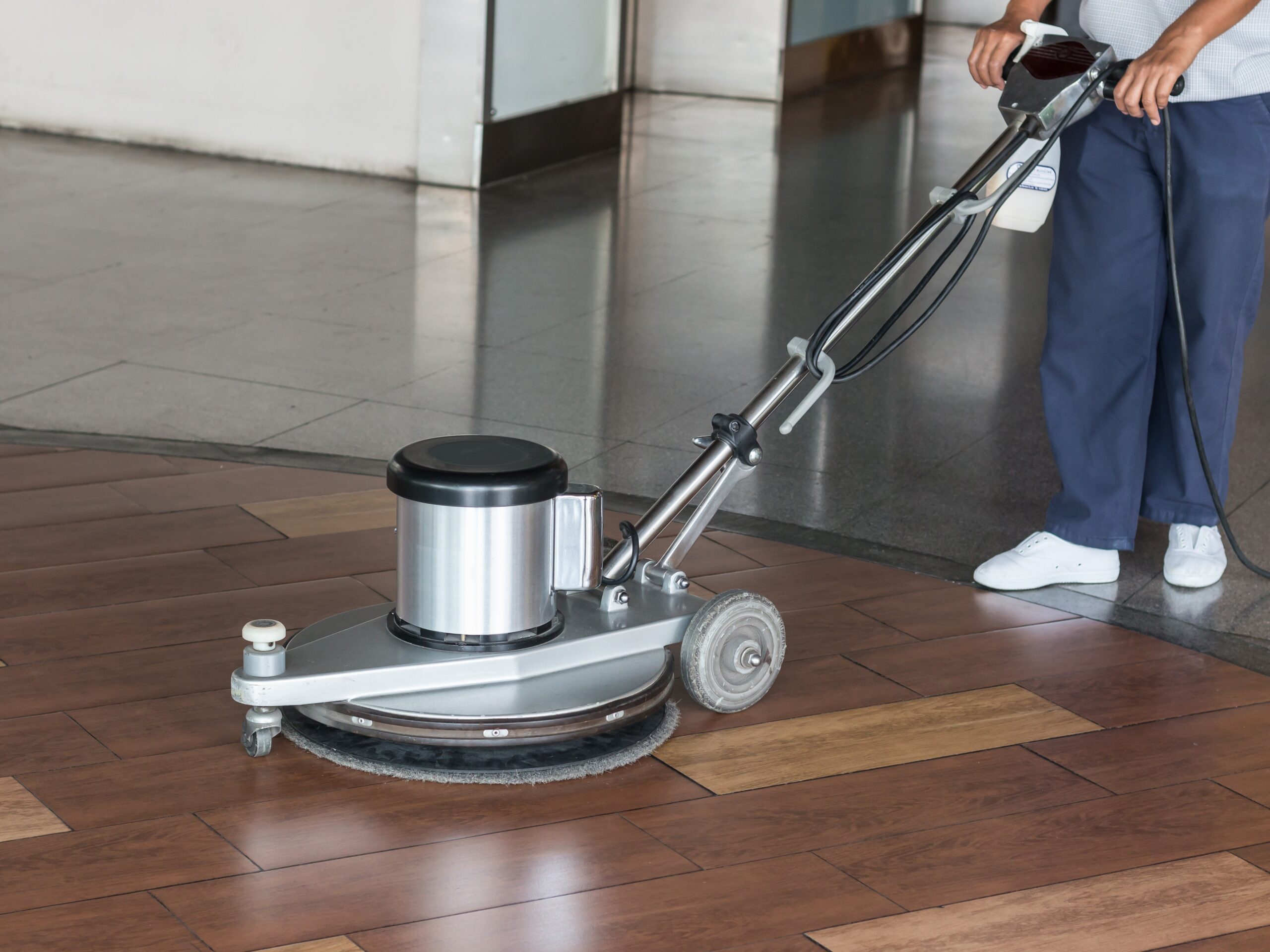 Woman cleaning the floor with polishing machine